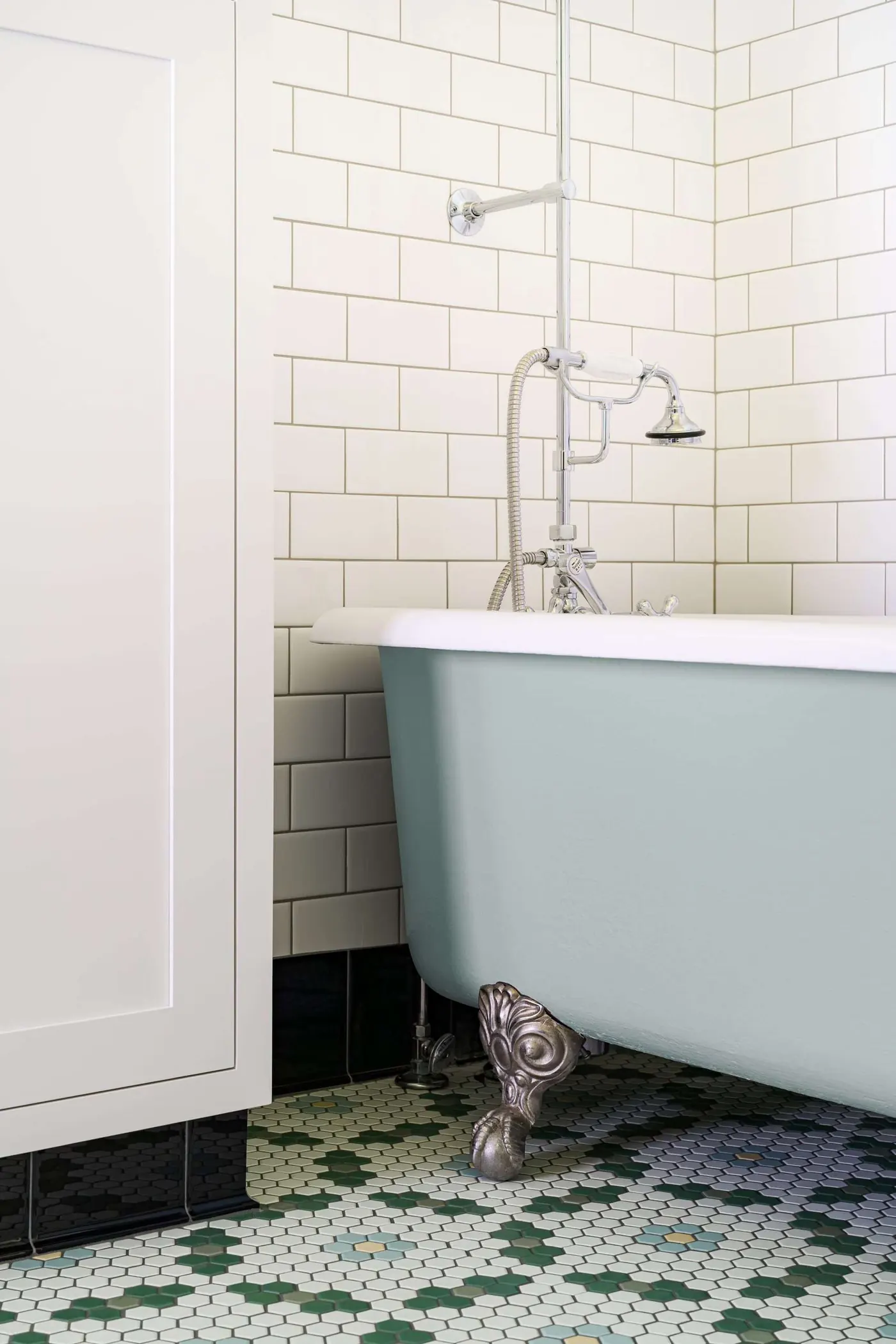 Restored 1910 bathroom with a clawfoot tub and green patterned tile floor, Salem